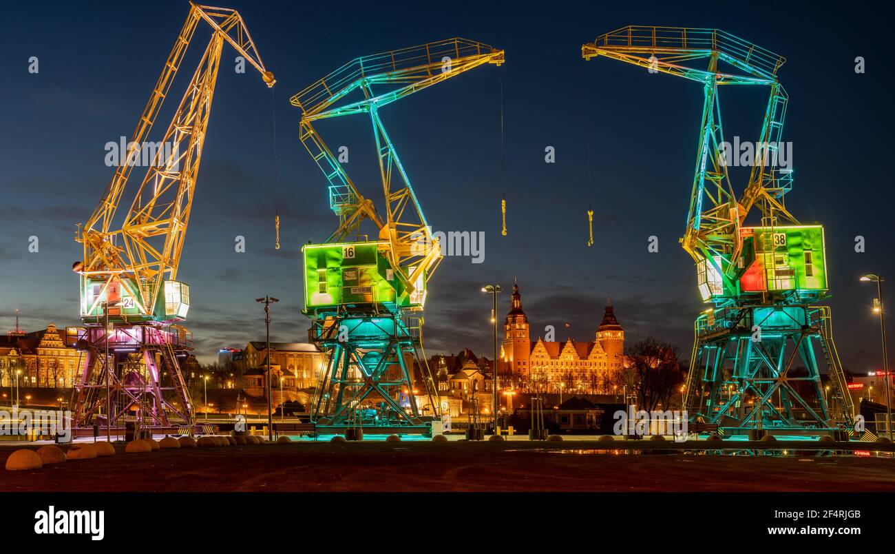 Beleuchtete alte Hafenkrane auf einem Boulevard in Stettin City Nachts Stockfoto