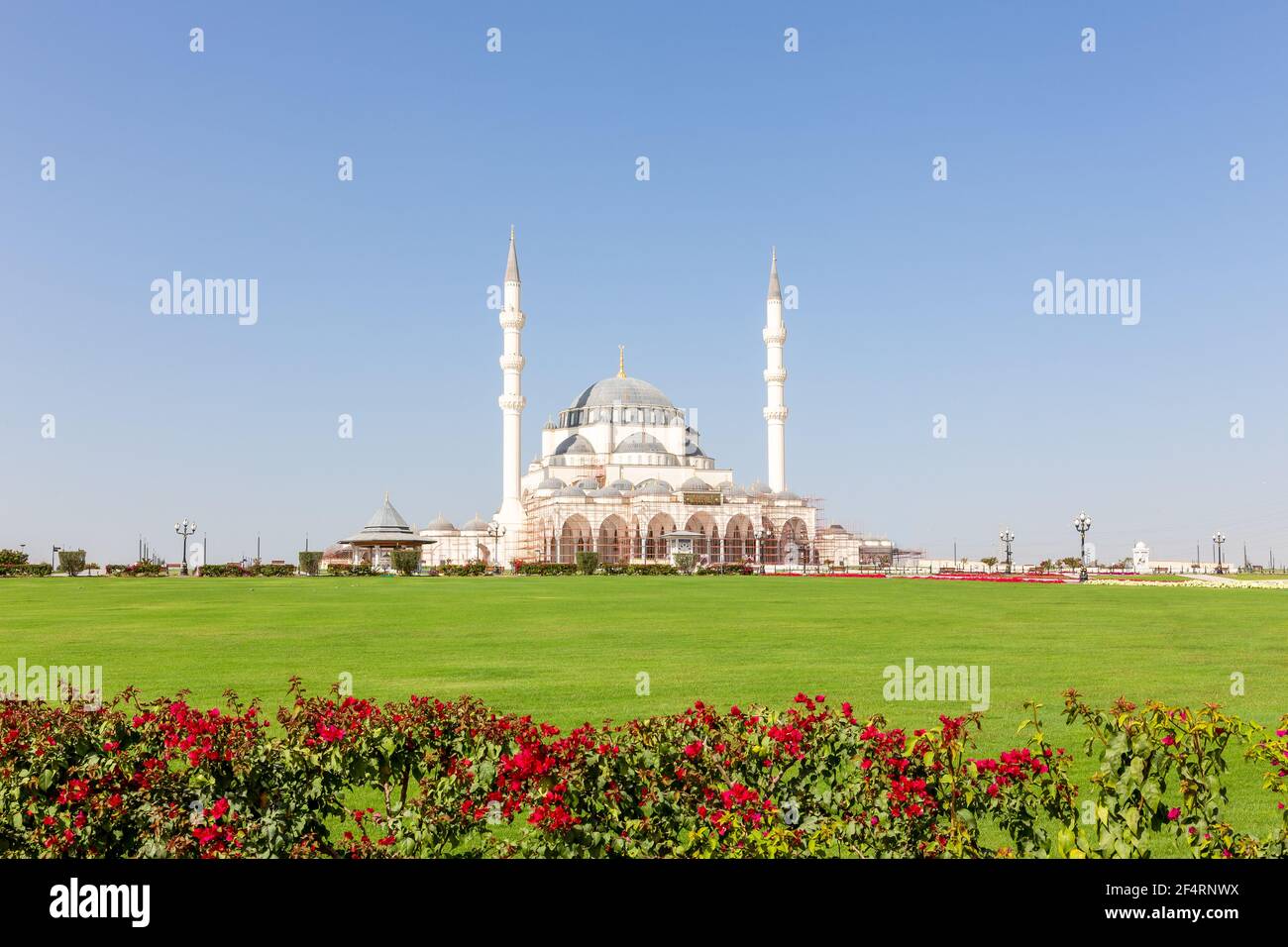 Neue Sharjah Moschee (Sharjah Masjid), die größte Moschee im Emirat Sharjah, den Vereinigten Arabischen Emiraten, weiße Sandsteinfassade mit Kuppeln. Stockfoto