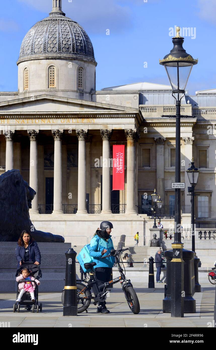 London, England, Großbritannien. Trafalgar Square. Lieferoo Lieferer auf einem EFF Elektrofahrrad. National Gallery dahinter Stockfoto