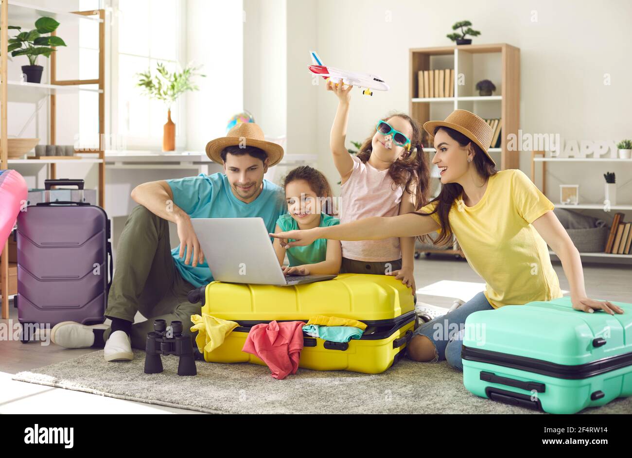 Glückliche Familie und Kinder mit Reisekoffer kaufen Ticket Buchung Hotel online Stockfoto