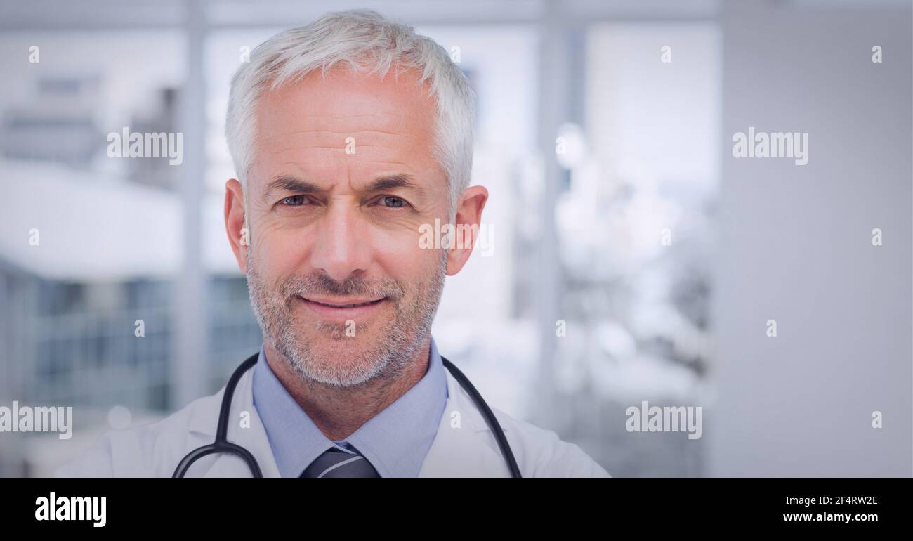 Potrait eines männlichen kaukasischen Senior Doktors, der lächelnd im Laborkittel trägt Im Krankenhaus Stockfoto