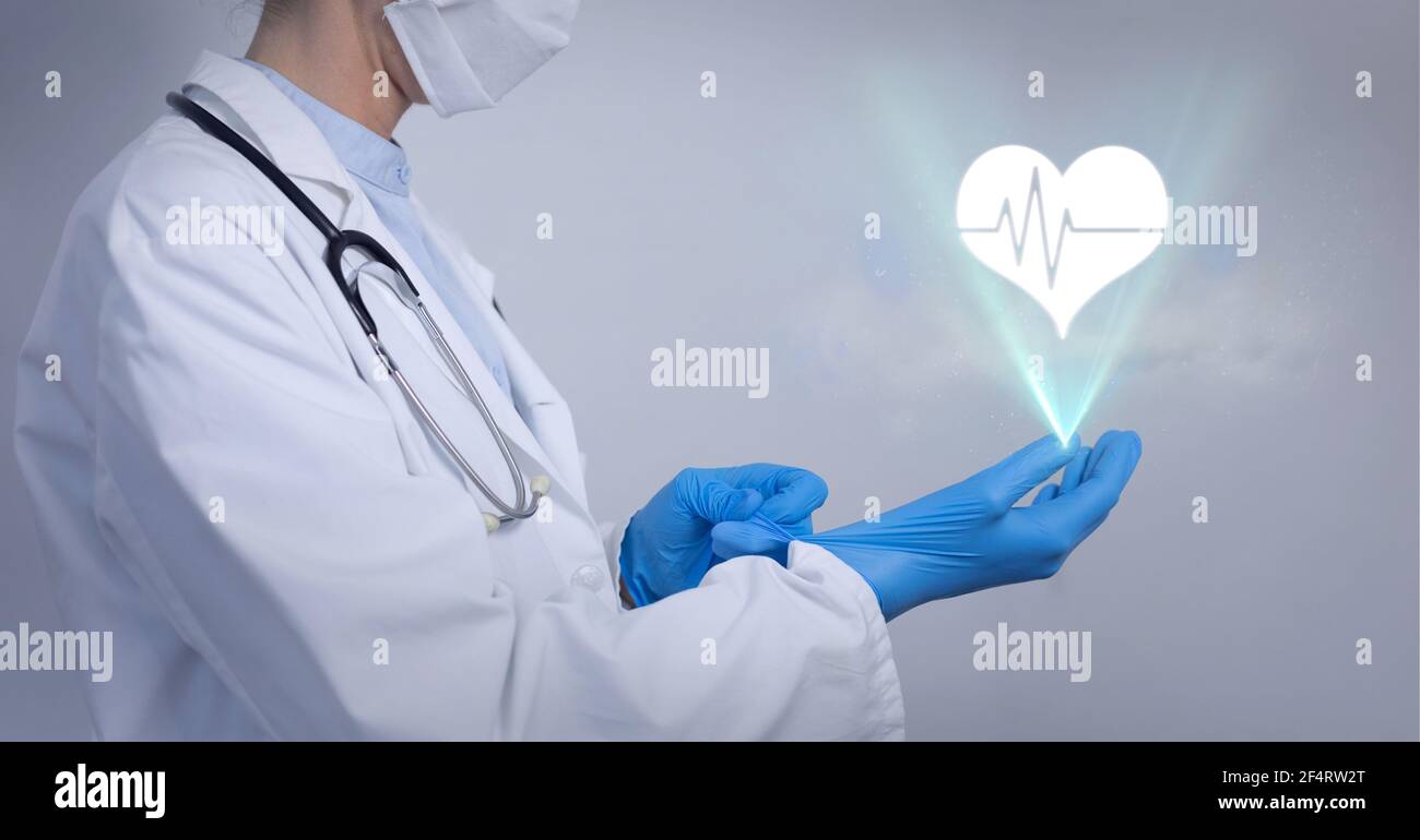 Symbol für das menschliche Herz über der mittleren Sektion des männlichen Arztes OP-Handschuhe Stockfoto