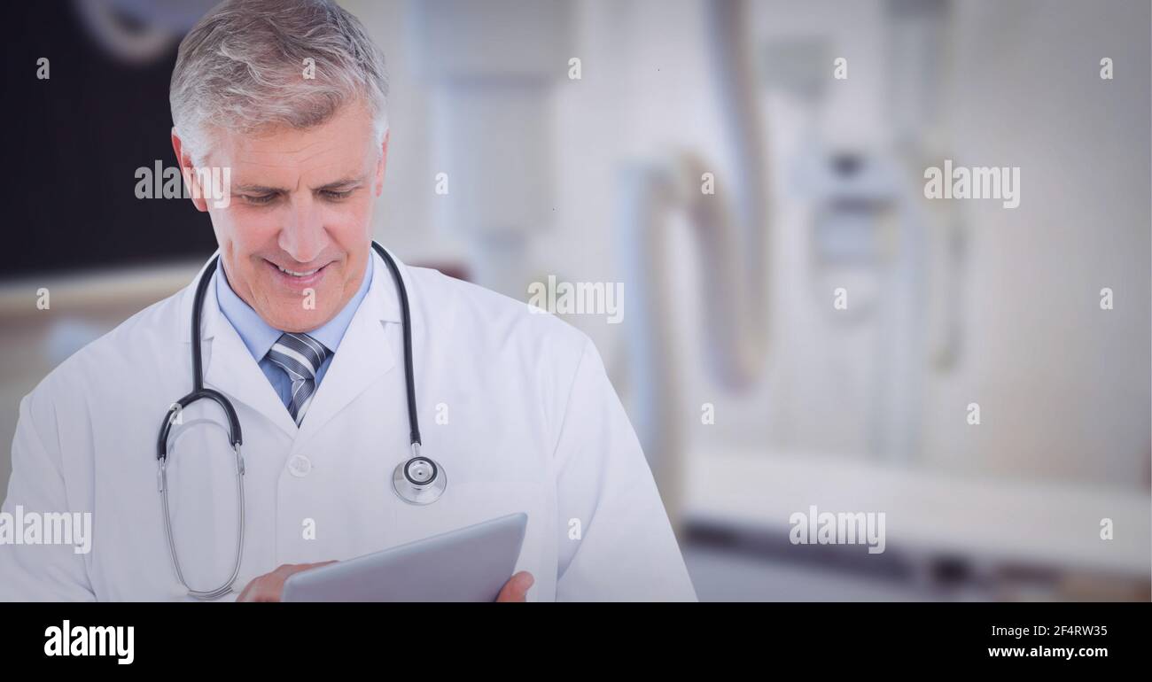 Porträt eines kaukasischen leitenden männlichen Arztes mit digitalem Tablet bei Krankenhaus Stockfoto