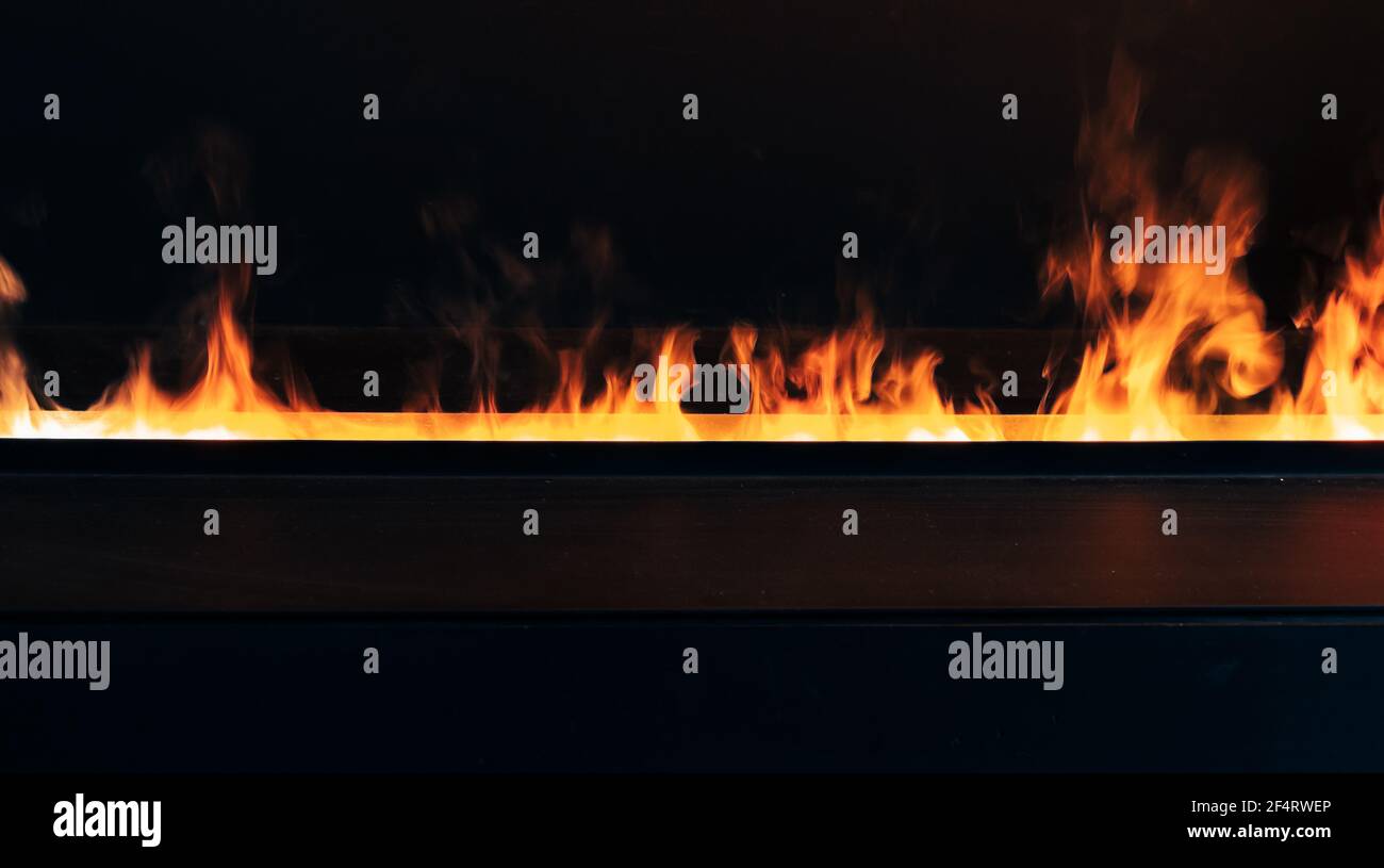 Brennendes Feuer über dunklem Hintergrund, moderne offene Kamin Nahaufnahme Foto Stockfoto
