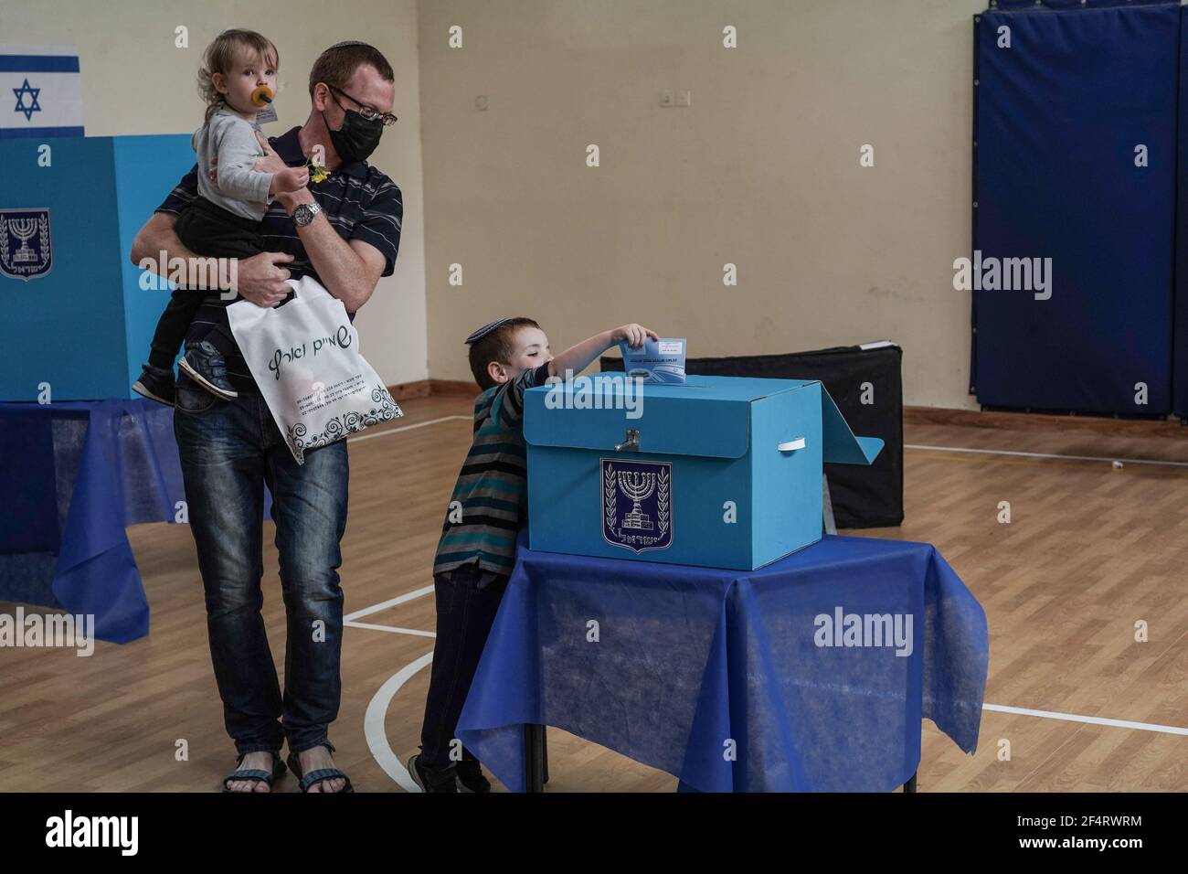 Jerusalem, Israel. März 2021, 23rd. Die Wähler geben ihre Stimmen bei den vierten nationalen Wahlen in Israel in zwei Jahren für die Knesset, das israelische Parlament, in eine Wahlurne ein. 15.000 Wahllokale werden landesweit betrieben, 30% mehr als im Jahr 2020, einschließlich in jedem betreuten Leben für ältere Menschen, innerhalb Krankenhaus Coronavirus Stationen und Quarantäne fahren durch Wahllokale für diejenigen, die positiv für COVID-19 getestet oder unter Quarantäne. Kredit: Nir Alon/Alamy Live Nachrichten Stockfoto