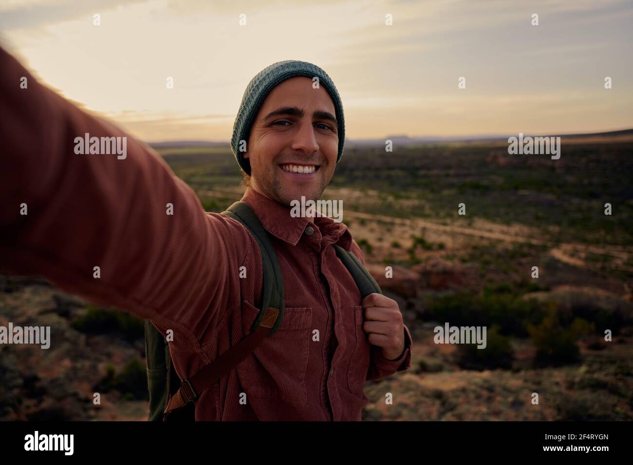 Junger Wanderer auf dem Berg während des Morgens Sonnenaufgang lächelnd und Gefühl Die Kamera sieht neu aus Stockfoto