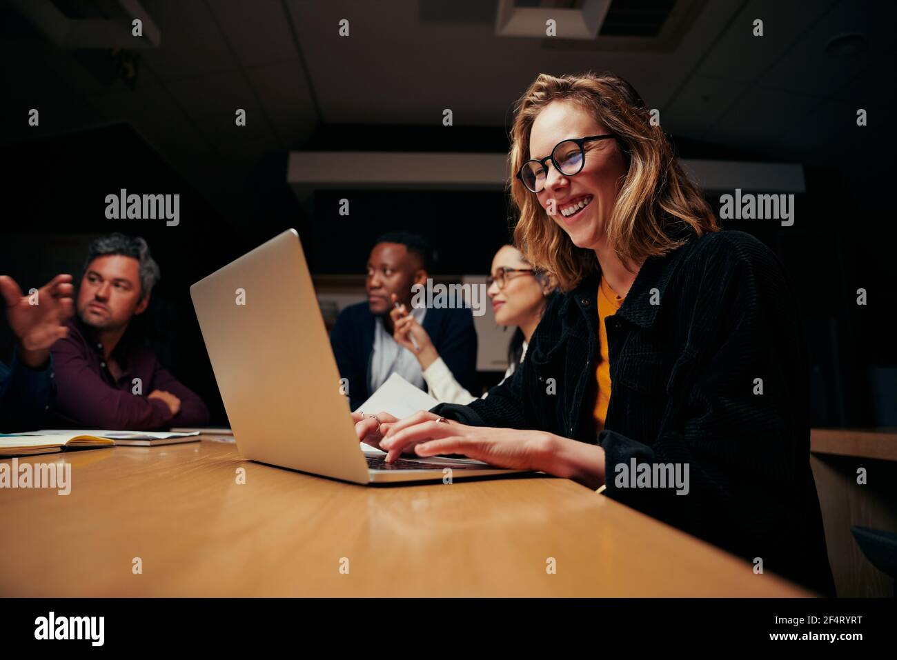 Porträt einer jungen erfolgreichen Geschäftsfrau, die mit einem Kollegen am Laptop sitzt Am Arbeitsplatz Stockfoto