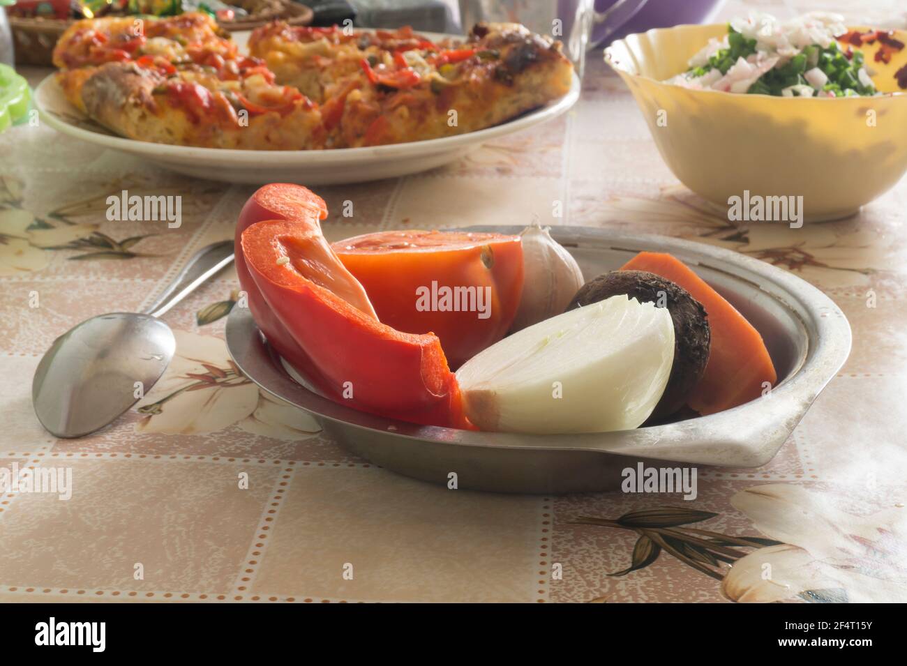 Paprikatomate und Zwiebel auf dem Tisch in der Küche. Frische Lebensmittel aus nächster Nähe Stockfoto