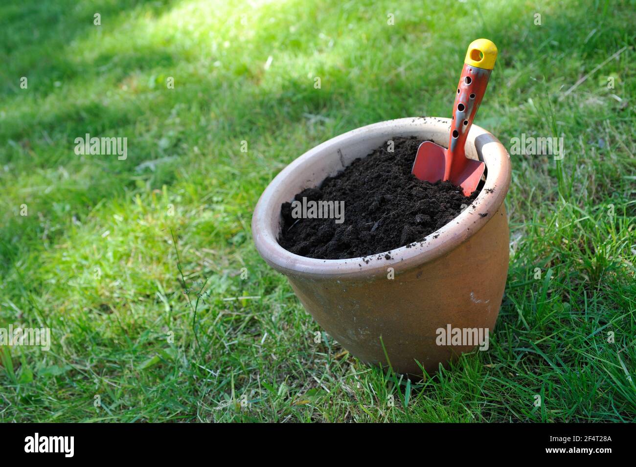 Blumentopf gefüllt mit Kompostboden und Gartenschaufel Stockfoto