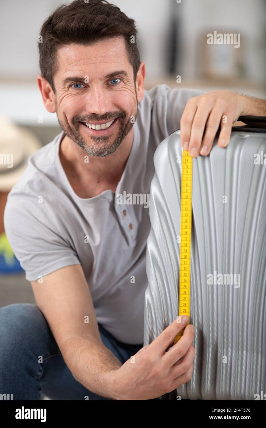 Mann überprüft die Größe des Handgepäcks mit einem Kassettenmessgerät Stockfoto