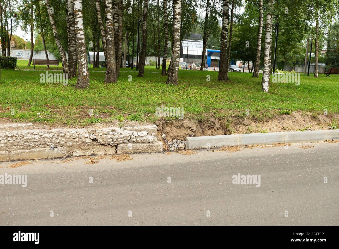 Schlecht durchgeführte Straßenreparaturen. Austausch des alten Bordsteines durch einen neuen Stockfoto