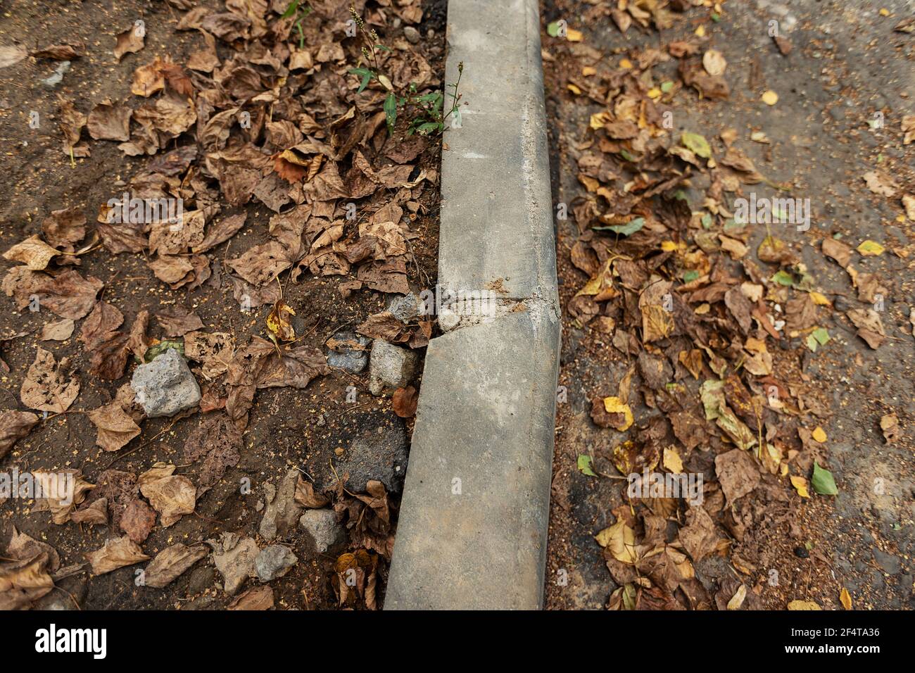 Schlecht durchgeführte Straßenreparaturen. Austausch des alten Bordsteines durch einen neuen Stockfoto