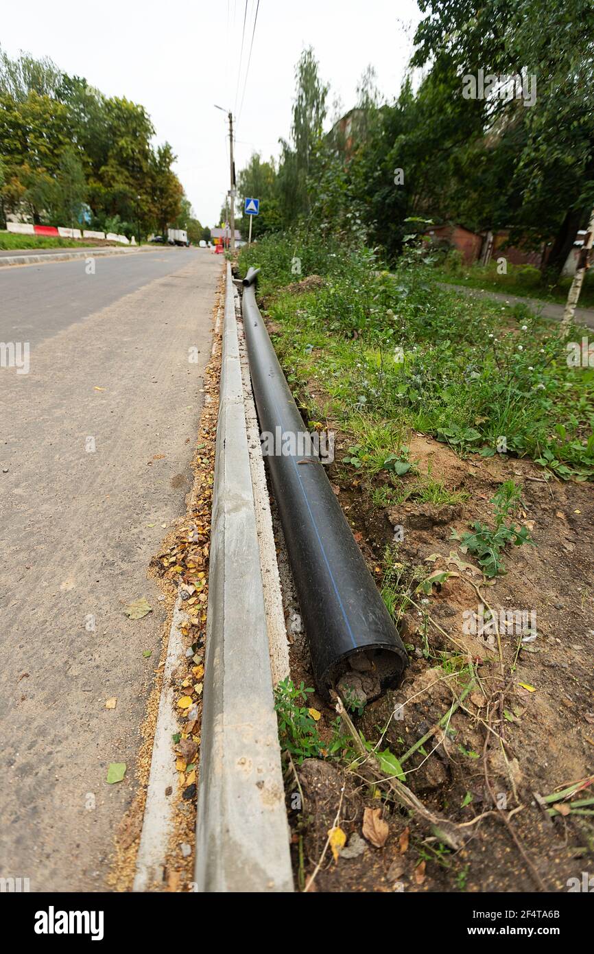 Schlecht durchgeführte Straßenreparaturen. Austausch des alten Bordsteines durch einen neuen Stockfoto
