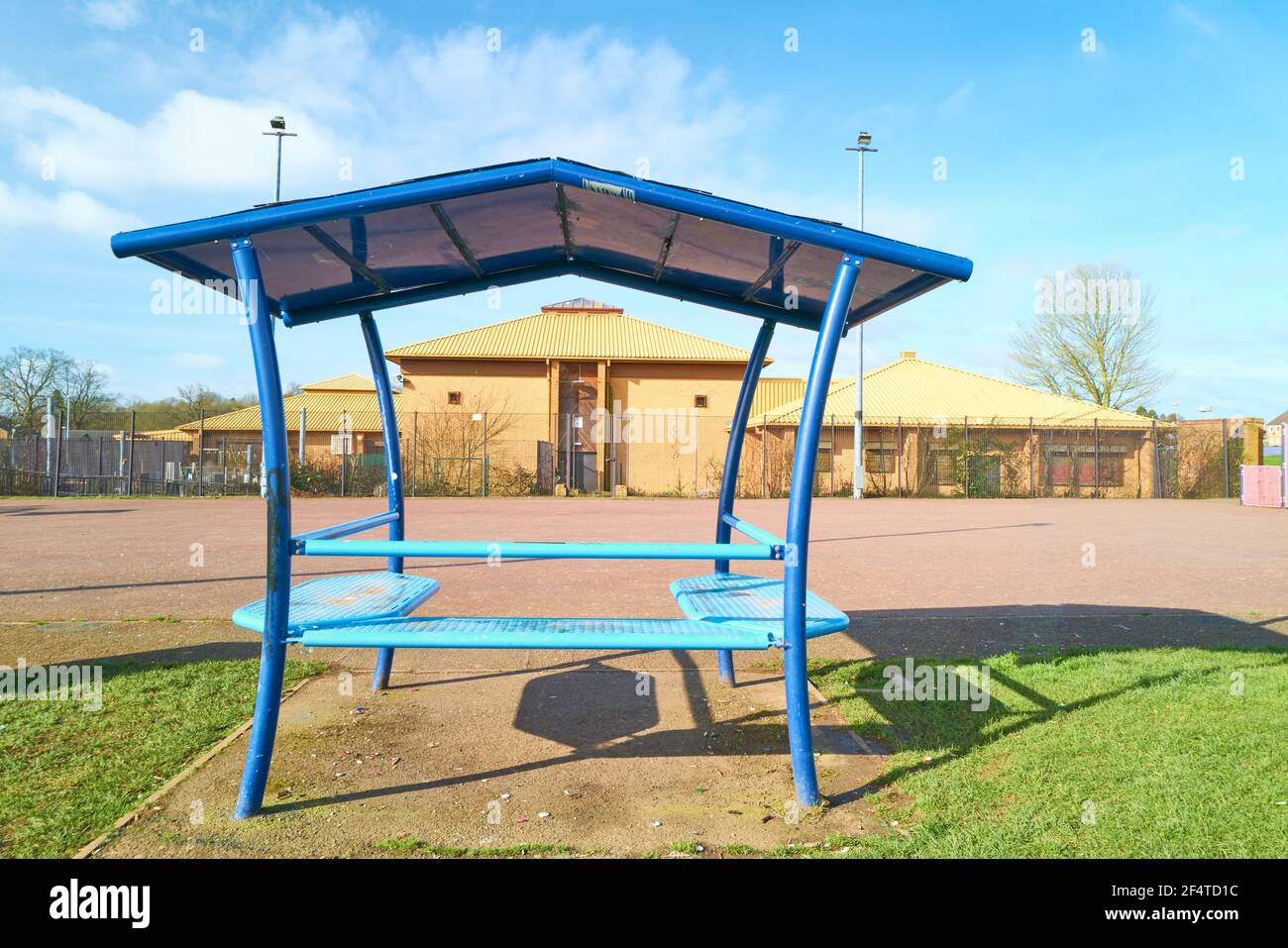 Metal Outdoor überdachte Sitz neben dem Sportplatz außerhalb des Kingswood Center, Corby, England. Stockfoto
