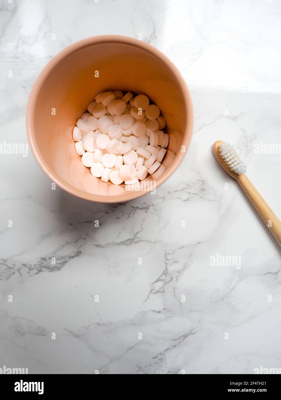 Bambuszahnbürste und Zahnstangen auf weißem Marmorhintergrund, Kunststoff frei tauschen. Zero Waste Lifestyle. Stockfoto