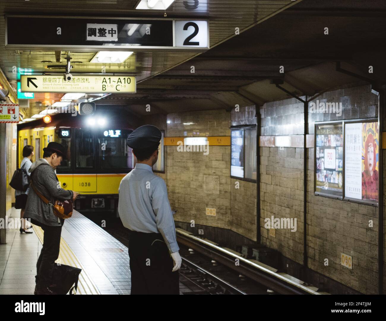 Tokio, Japan - U-Bahn kommt der Bahnhof und der Sicherheitsbeamte auf dem Bahnsteig. Stockfoto