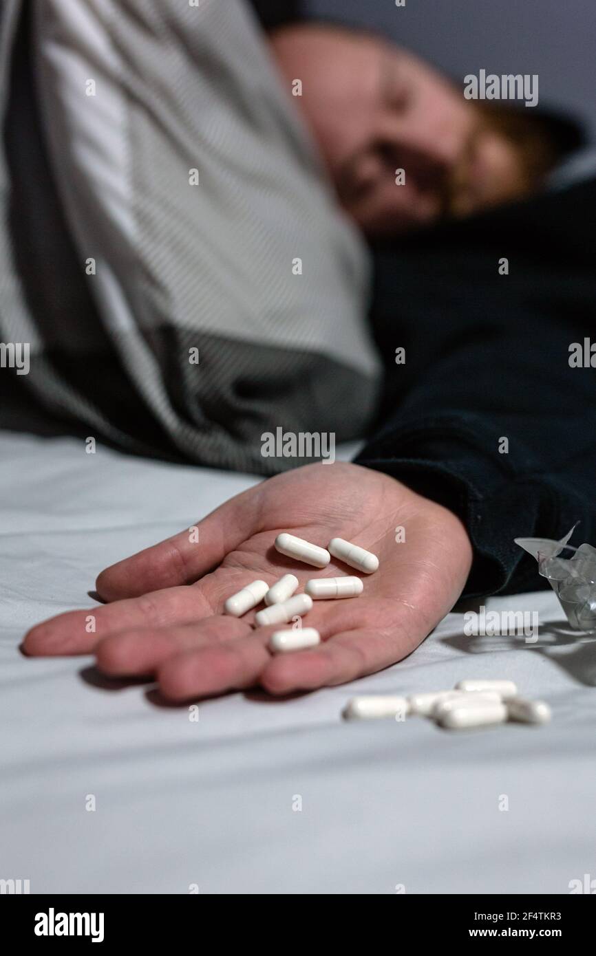 Unbekannter Mann begeht Selbstmord durch Überdosierung auf Medikamente. Nahaufnahme von Überdosis-Pillen und Süchtigen. Überdosierung, Selbstmord, Depression Konzept Stockfoto