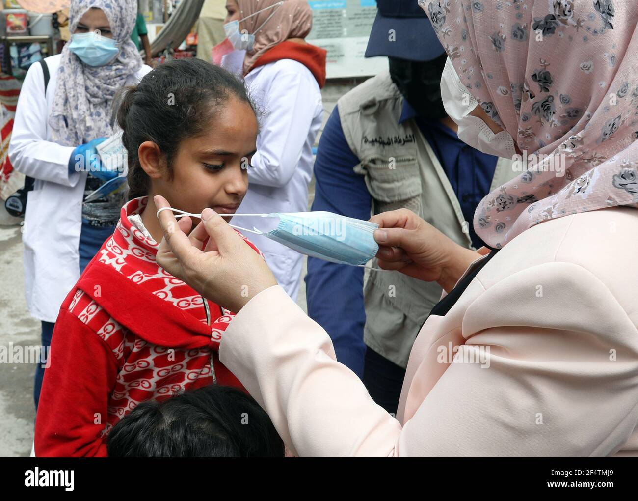 Bagdad. März 2021, 23rd. Ein Gesundheitshelfer hilft einem Kind bei der Gesichtsmaske während einer Sensibilisations- und Erkennungskampagne COVID-19 in Bagdad, Irak, am 23. März 2021. Das irakische Gesundheitsministerium berichtete am Montag über 4.655 neue COVID-19 Fälle, was die landesweite Gesamtzahl auf 798.547 erhöht. Quelle: Khalil Dawood/Xinhua/Alamy Live News Stockfoto