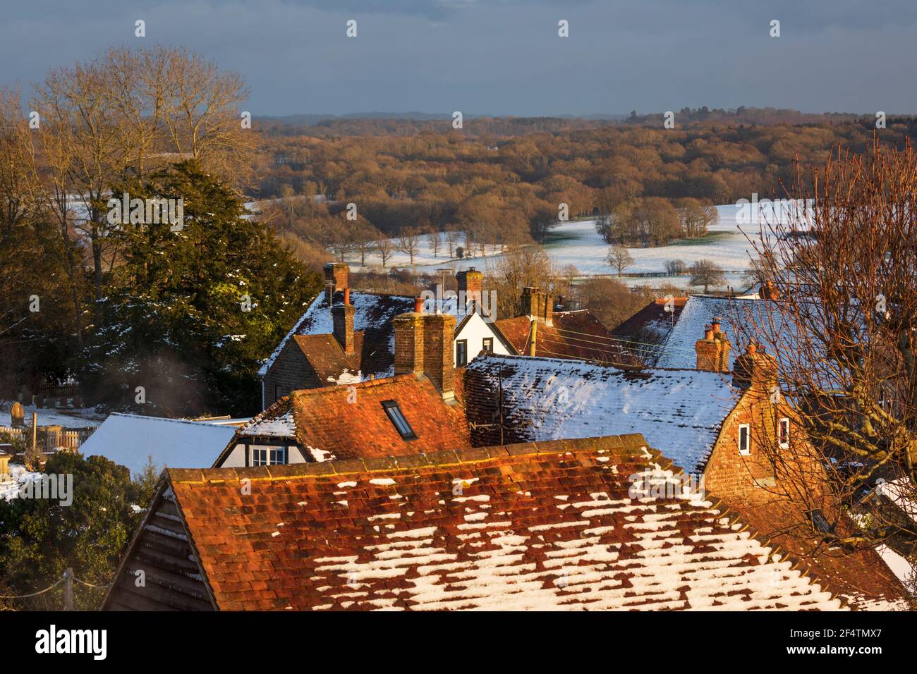 Blick über die Dächer der Hütte und High Weald Landschaft im Winterschnee im späten Nachmittag Sonnenlicht, Burwash, East Sussex, England, Vereinigtes Königreich, Europa Stockfoto