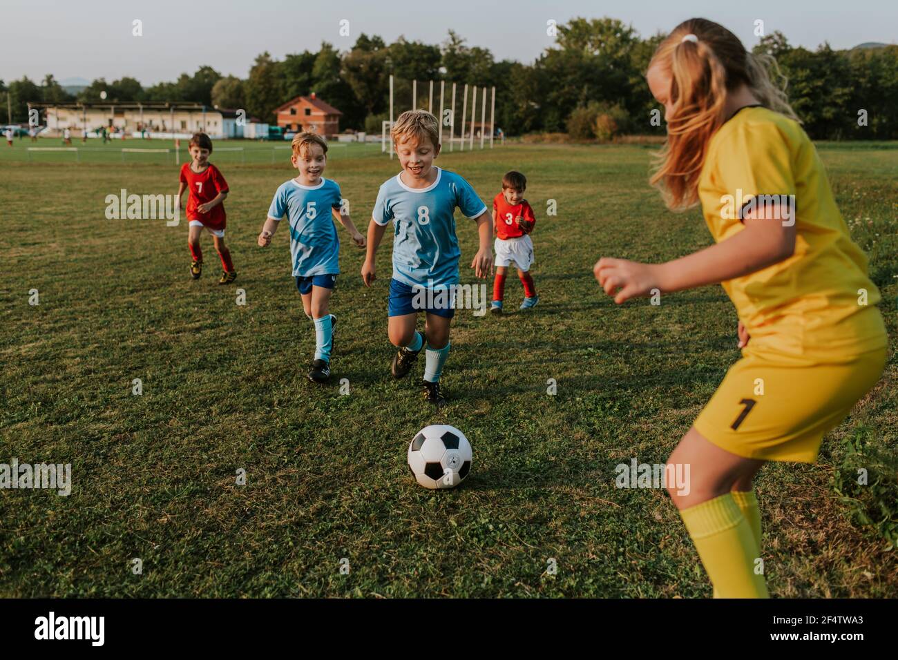 Kinder spielen draußen Fußball. Mädchen Torhüter fangen Fußball bei Amateur-Wettbewerb. Stockfoto