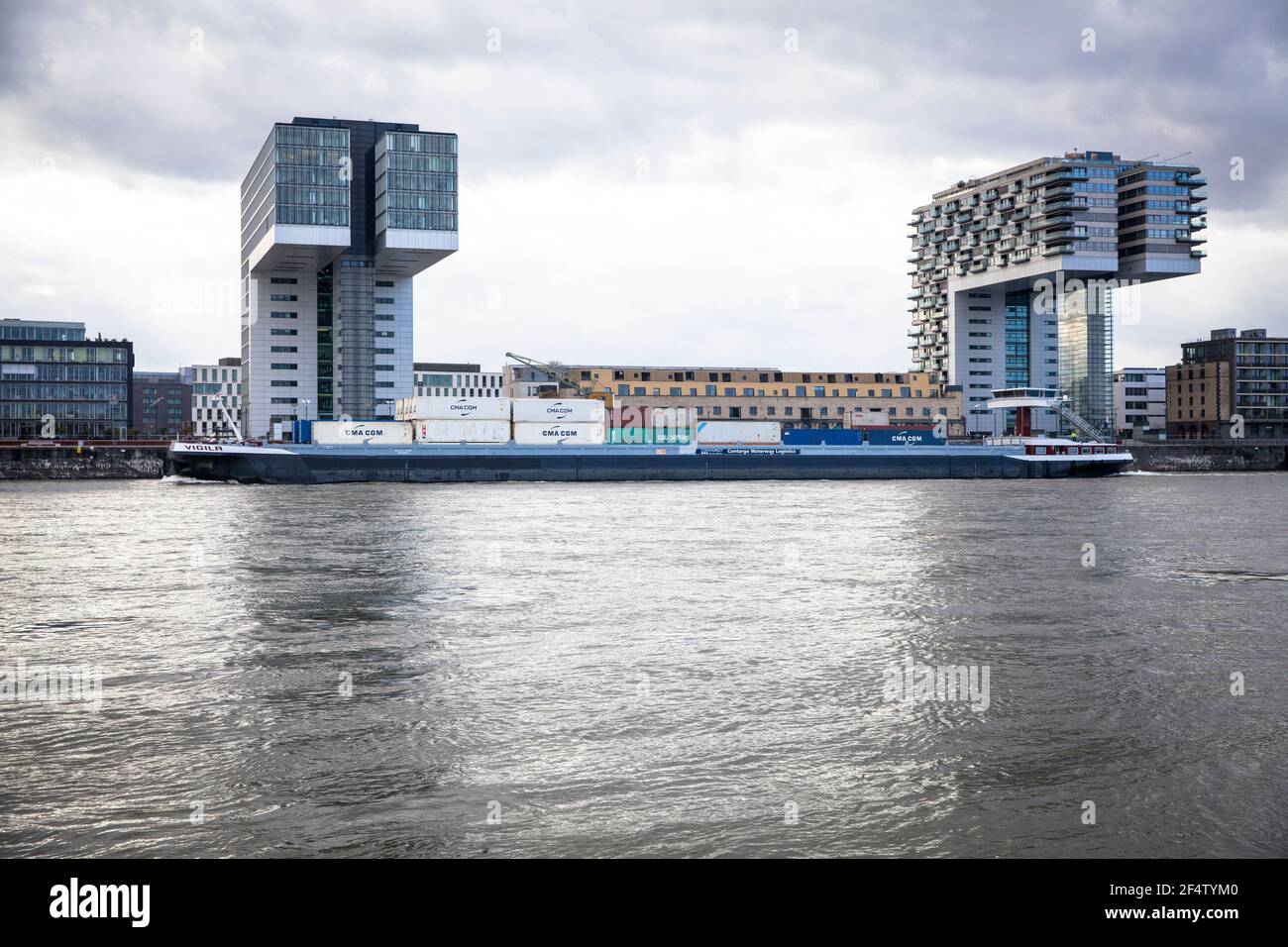 Containerschiff vor den Kranhäusern im Rheinauer Hafen, Köln. Containerschiff vor den Kranhäusern im Rheinauhafen, Köln, De Stockfoto