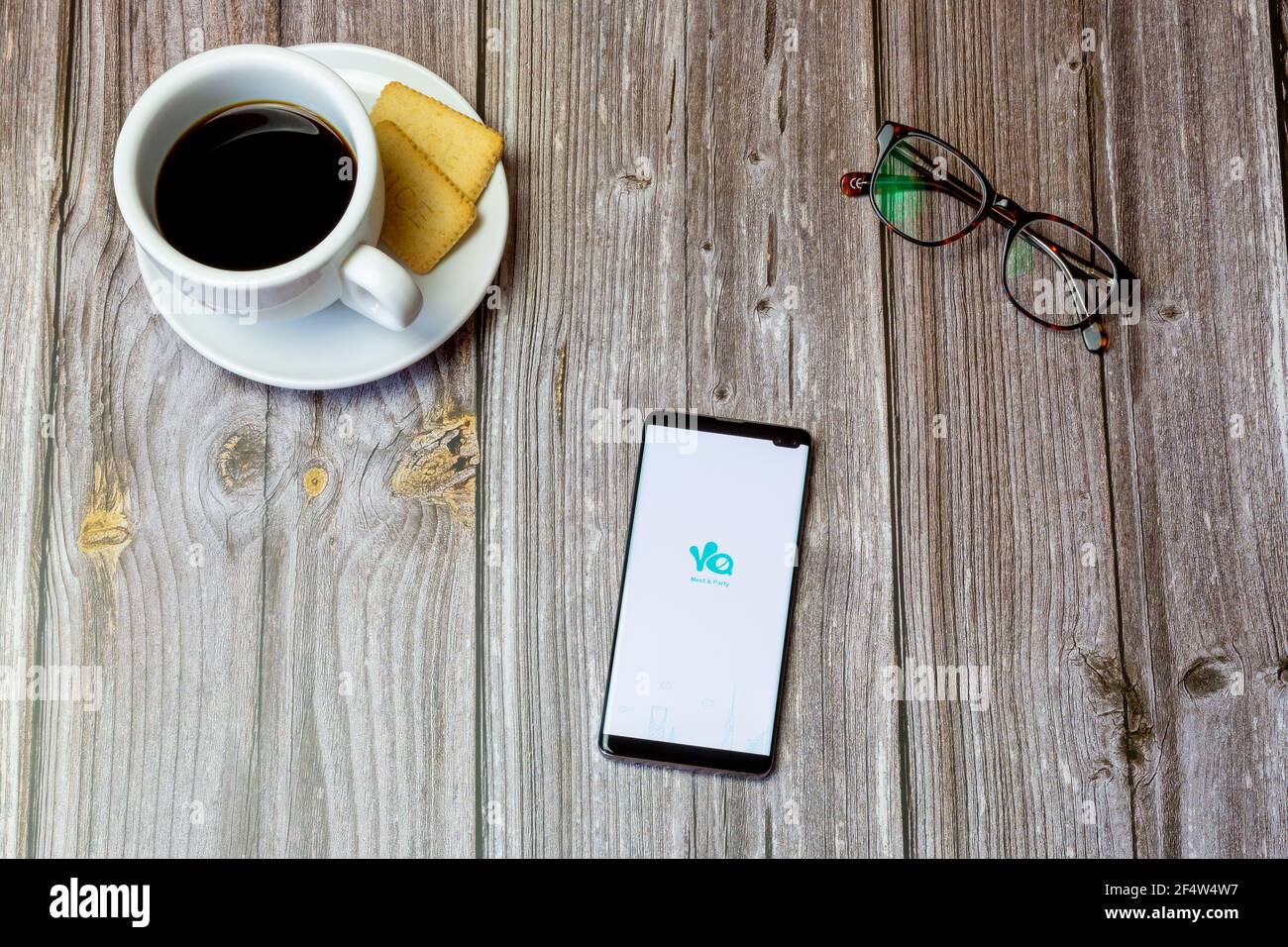 Ein Handy oder Handy auf einem Holz gelegt Tabelle mit der Yalla-App auf dem Bildschirm geöffnet Stockfoto