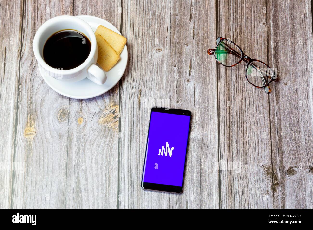 Ein Handy oder Handy auf einem Holz gelegt Tabelle mit der Anchor by spotify App auf dem Bildschirm geöffnet Stockfoto