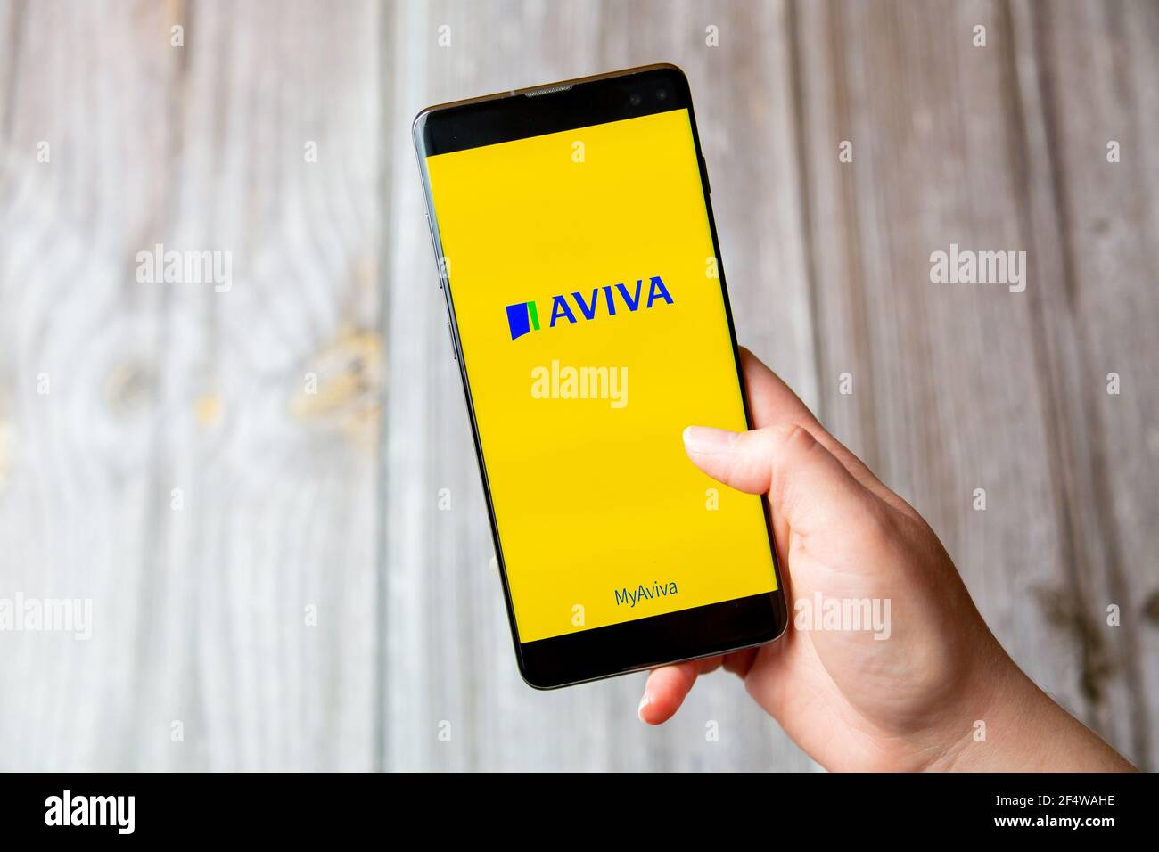 Ein Mobiltelefon oder Mobiltelefon, das in einem gehalten wird Hand mit der AVIVA App geöffnet auf dem Bildschirm Stockfoto