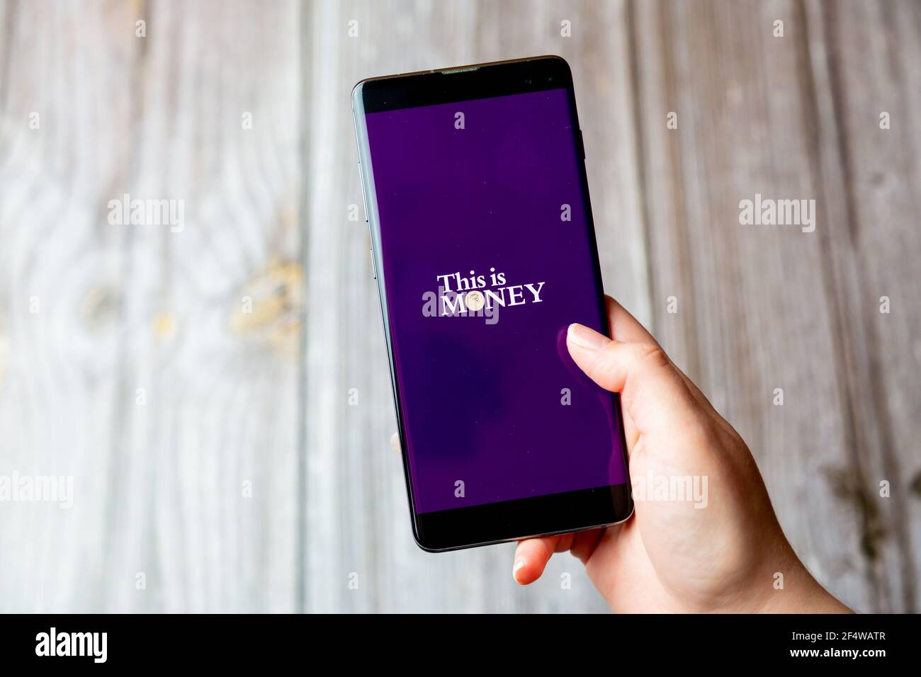 Ein Mobiltelefon oder Mobiltelefon, das in einem gehalten wird Hand mit der This is Money App auf dem Bildschirm geöffnet Stockfoto