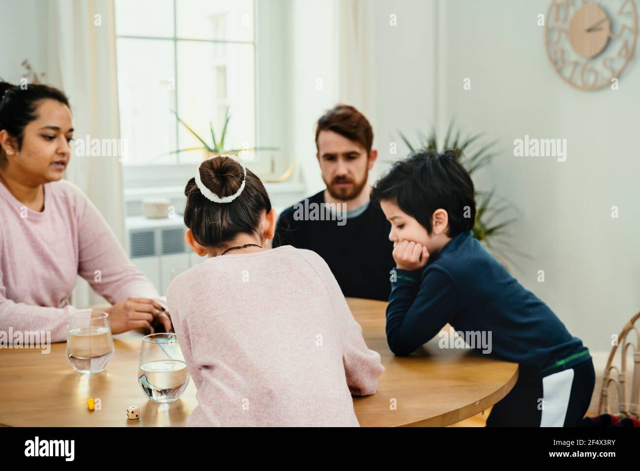 Familie spielt mit Brettspiel zusammen am Tisch Stockfoto