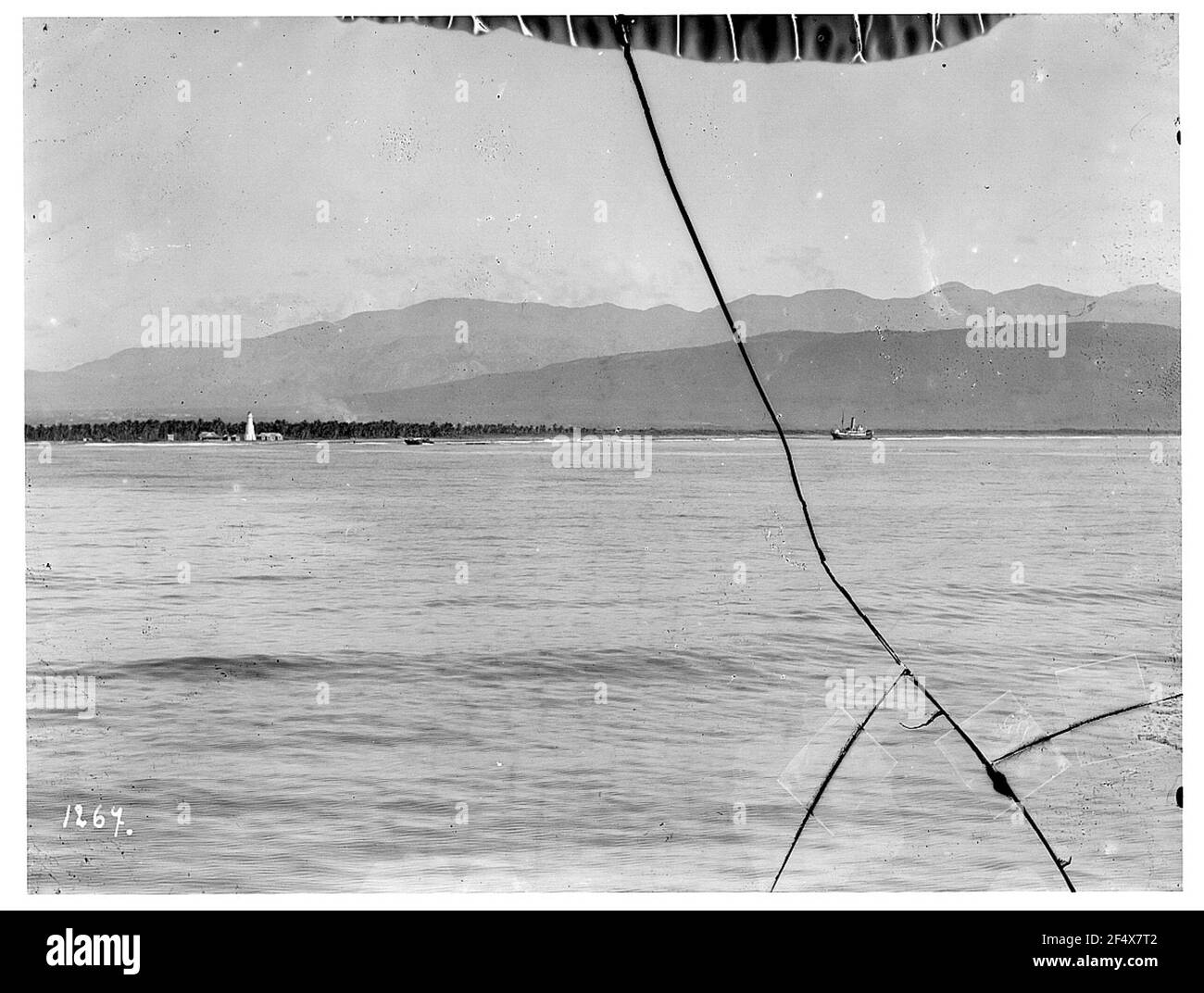 In Kingston, Jamaika. Blick von einem Kreuzfahrtschiff Hapag auf der Karibik mit Dampfer gegen Küstenstreifen mit Leuchtturm gegen Berge Stockfoto