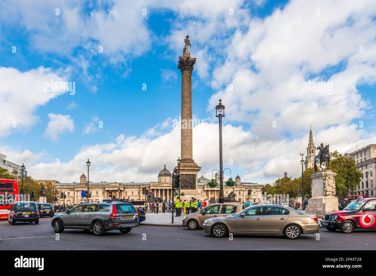 Autoverkehr auf dem Trafalgar Square und der Nelson's Column und im Hintergrund die National Gallery, Central London, England, Vereinigtes Königreich England, Vereinigtes Königreich Stockfoto