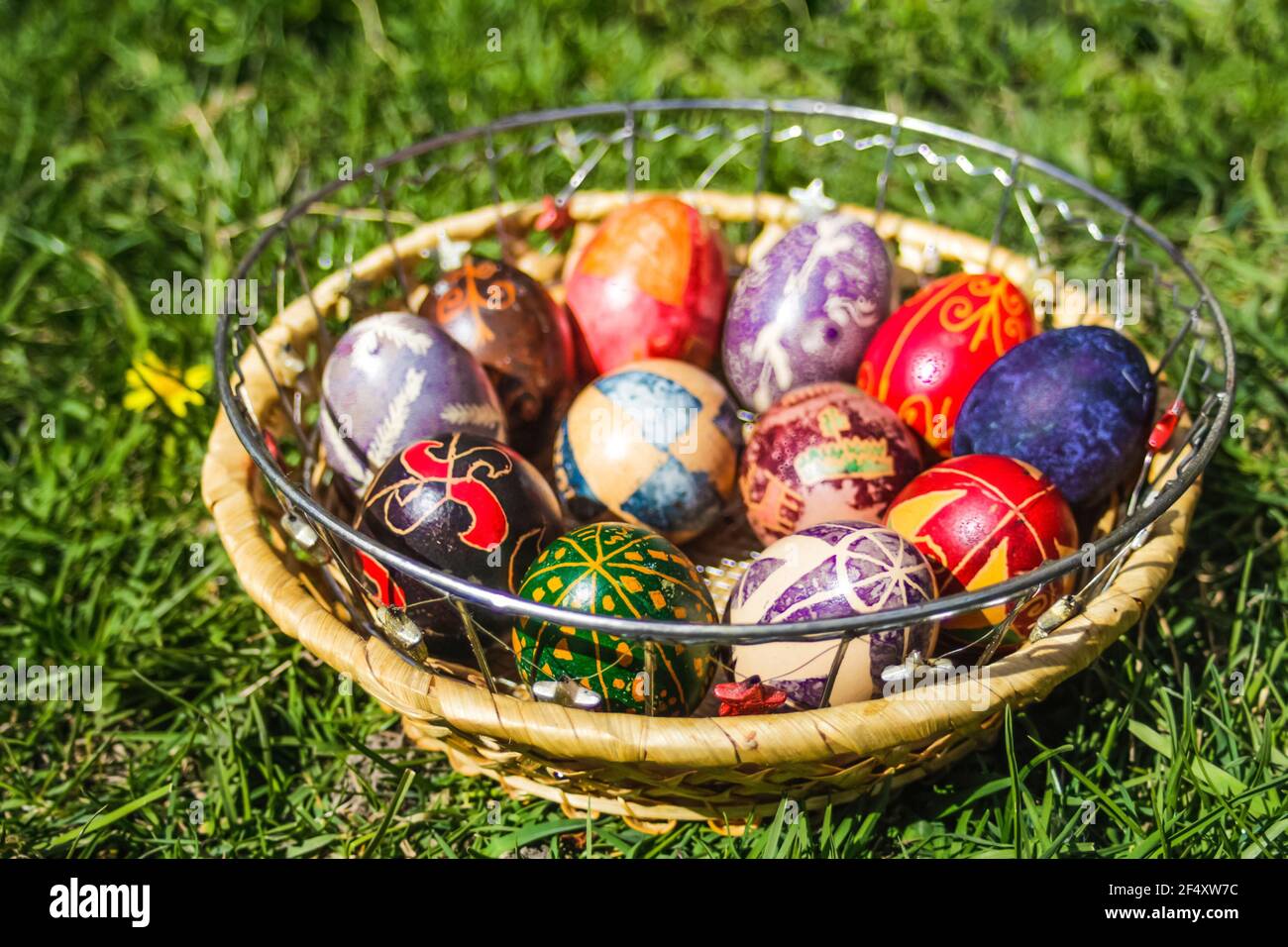 Defokussieren Sie bunte ostereier. Dekoriert pysanka und krashanka. Holzkorb Mit Ostereiern Im Grünen Gras. Nahaufnahme. Festlich. Nicht fokussiert Stockfoto