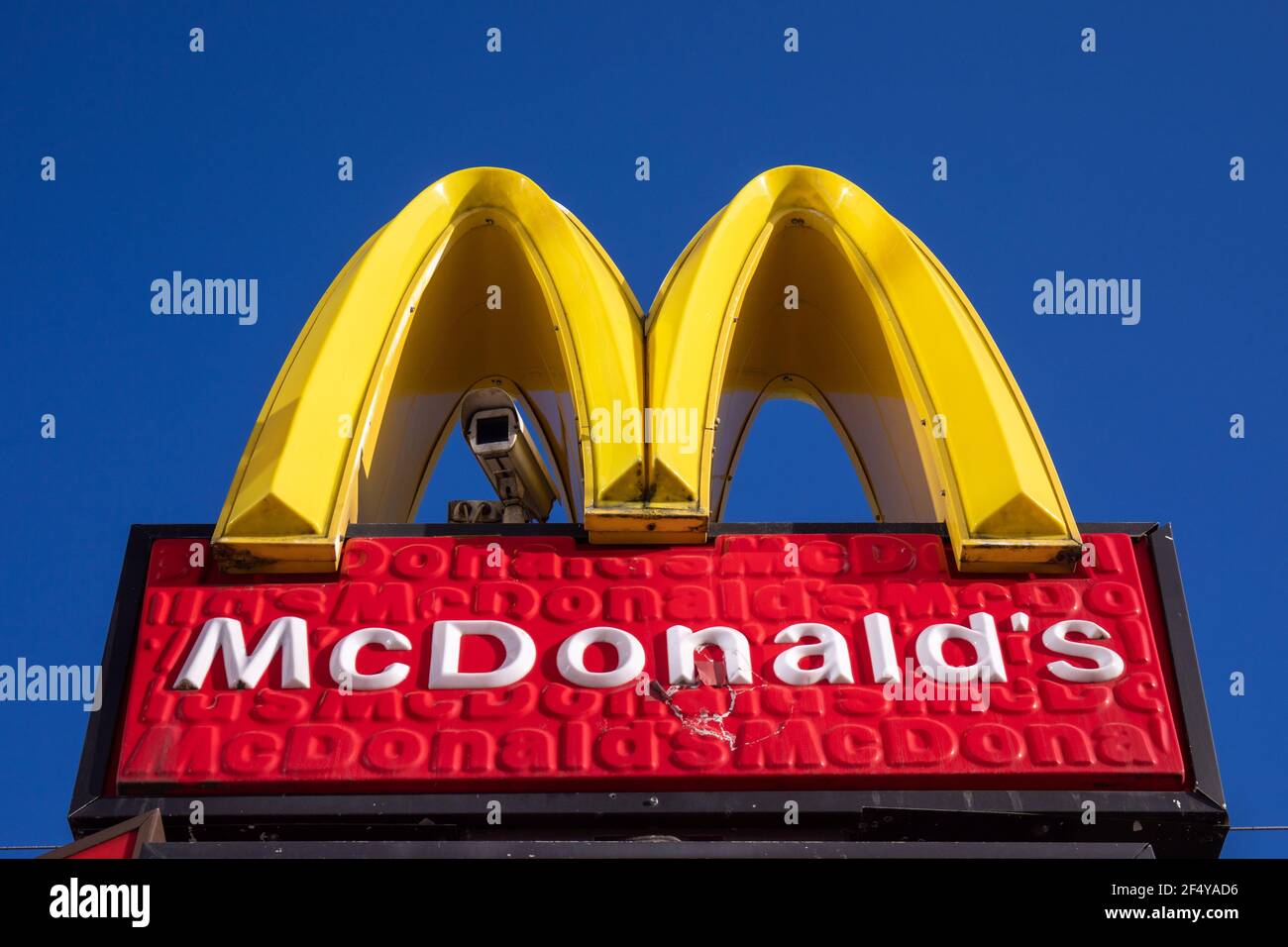 McDonald's-Lichtschild mit Überwachungskamera gegen klaren blauen Himmel Stockfoto