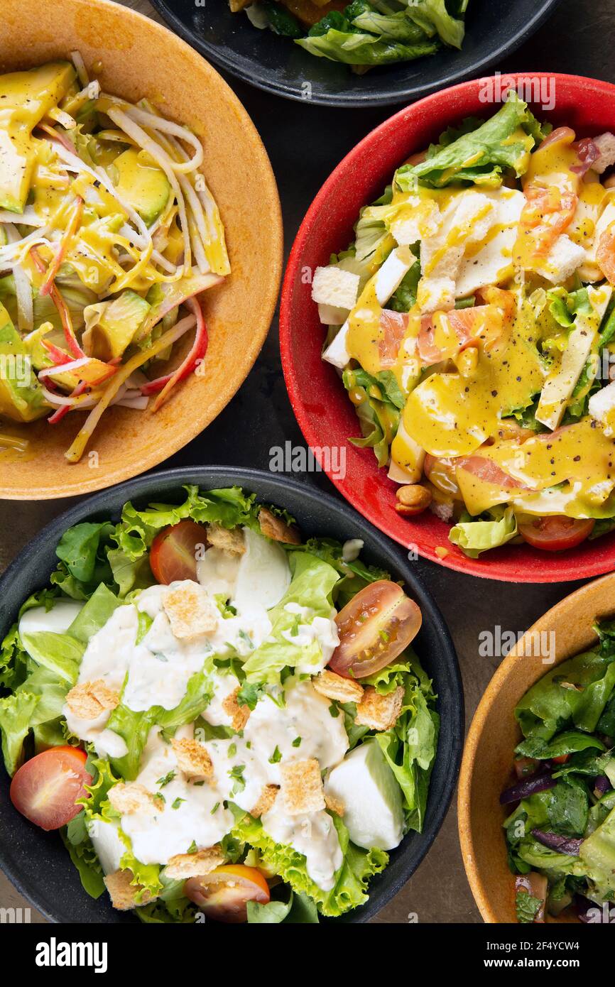 Salate auf bunten Schüsseln, Draufsicht. Stockfoto