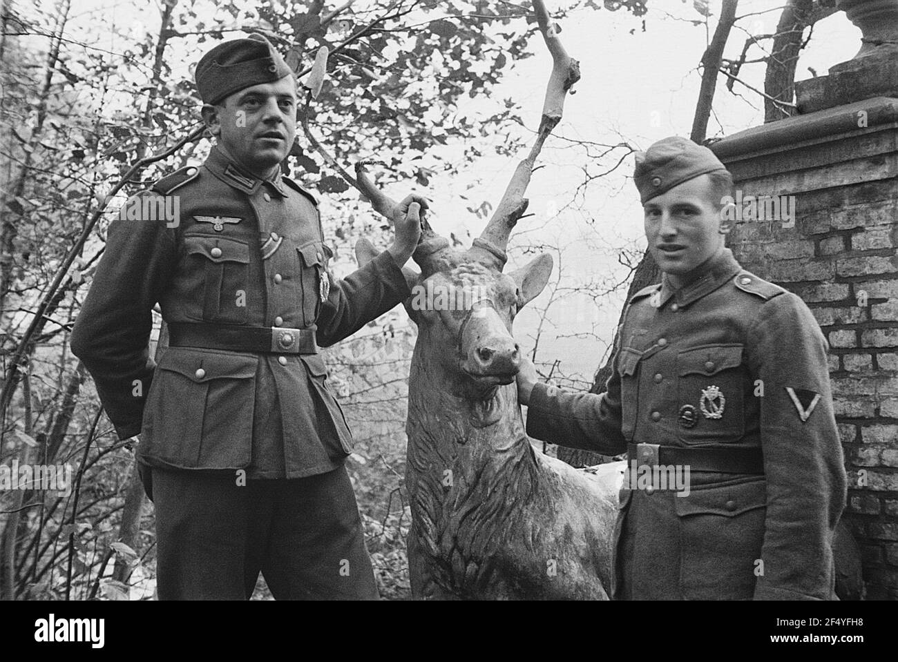 Zweiter Weltkrieg. Niederlande unter deutscher Besatzung. Zwei Verwandte der deutschen Wehrmacht in einem Park mit Plastik eines Lügerhirsches (gut bei Den Haag) Stockfoto