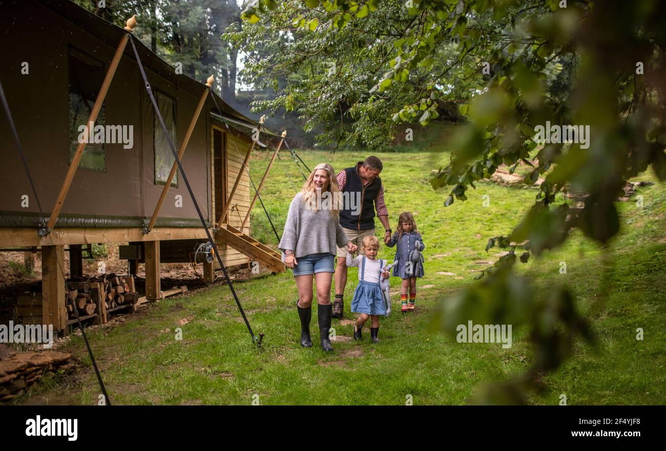Familie zu Fuß außerhalb Hütte im Wald Stockfoto