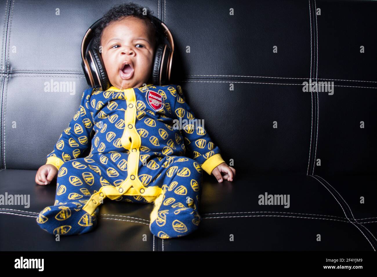 Niedlicher Junge in einem Arsenal Baby-Grow Stockfoto