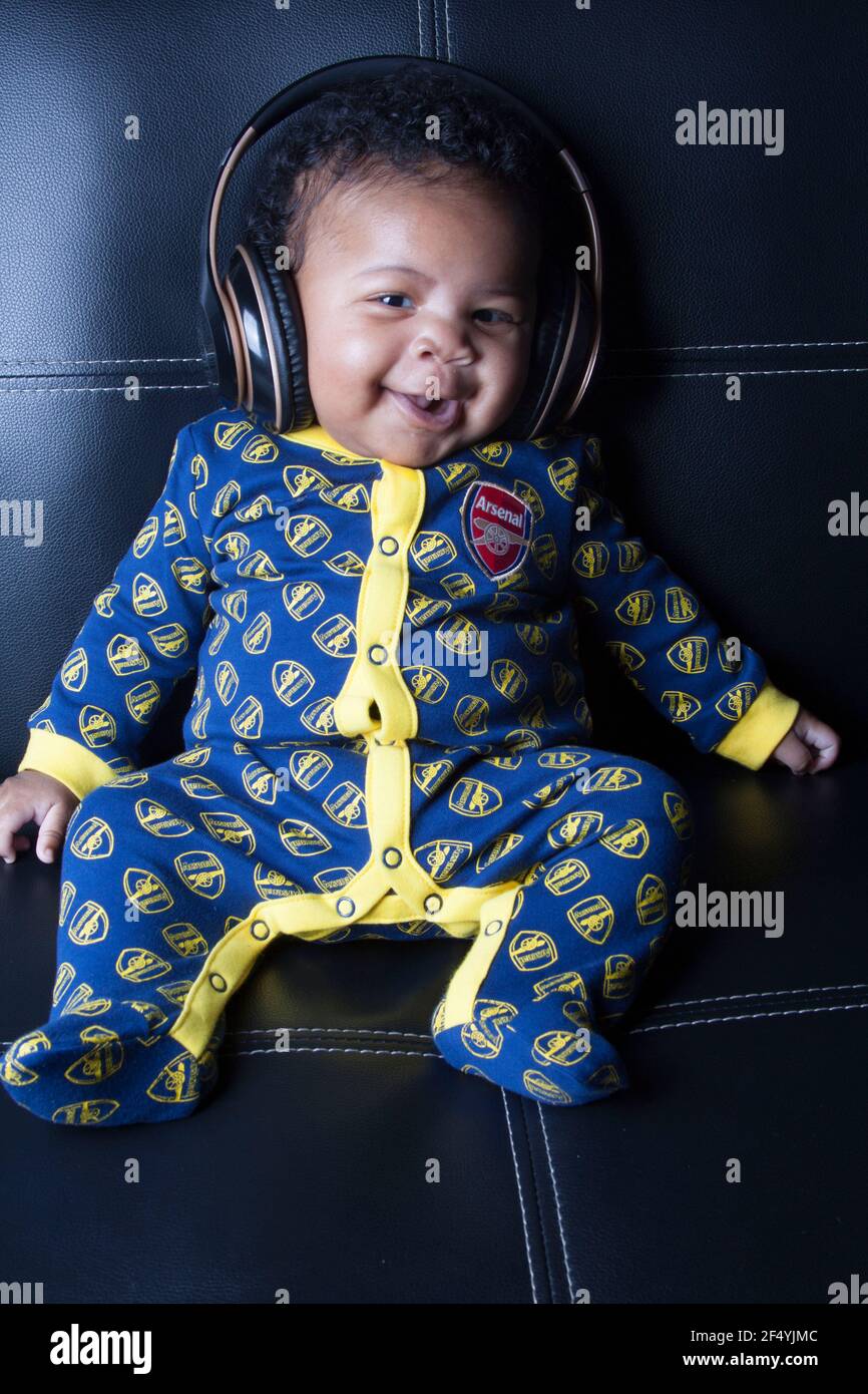 Niedlicher Junge in einem Arsenal Baby-Grow Stockfoto