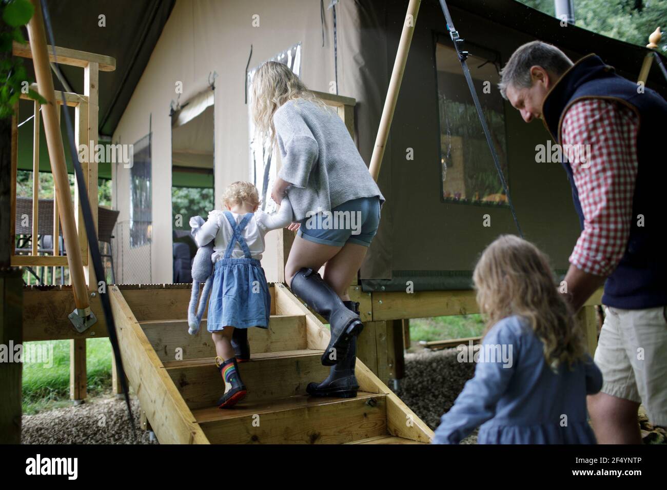 Familie hält die Hände, die die Stufen zur Hütte hinauf gehen Stockfoto