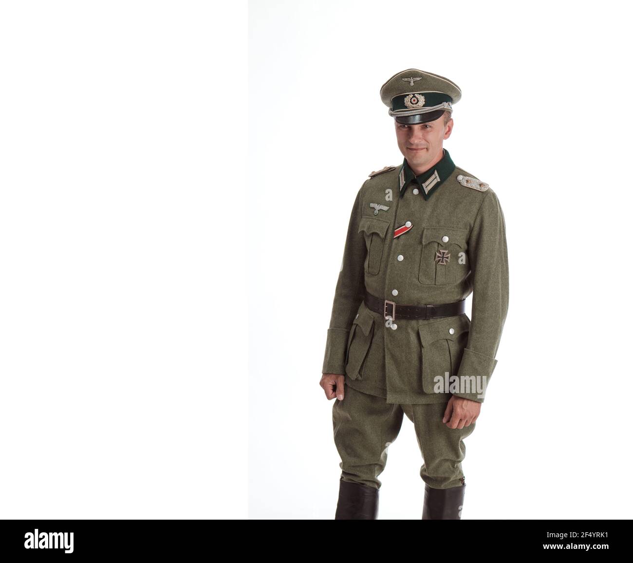 Mann Schauspieler in historischer Militäruniform als Offizier der deutschen Armee während des Zweiten Weltkriegs, posiert auf einem schwarzen Hintergrund in einem blauen szenischen Licht Stockfoto