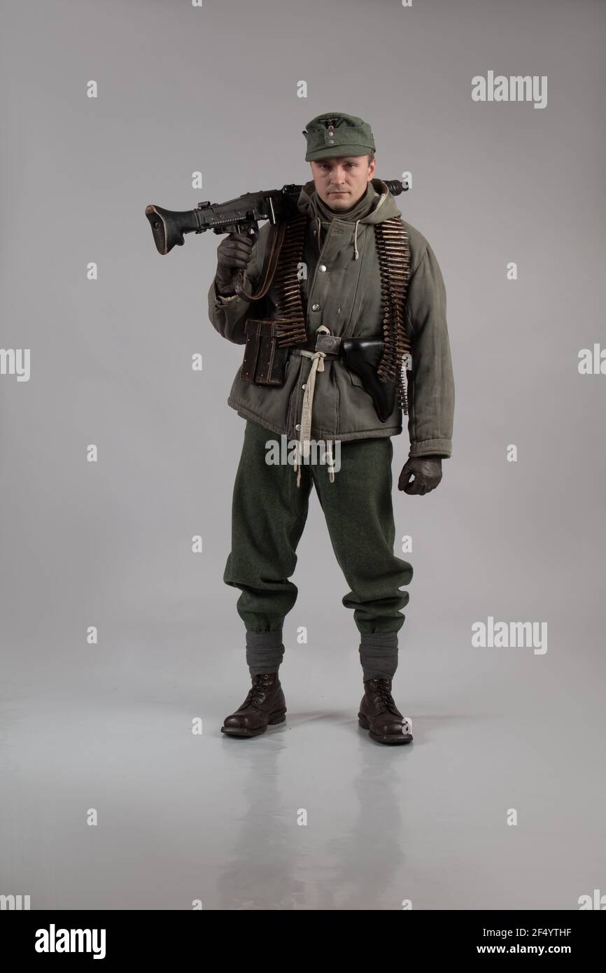 Männlicher Schauspieler in der Winteruniform eines deutschen Soldaten, der Periode 1942, dem Zweiten Weltkrieg, posiert auf grauem Hintergrund Stockfoto