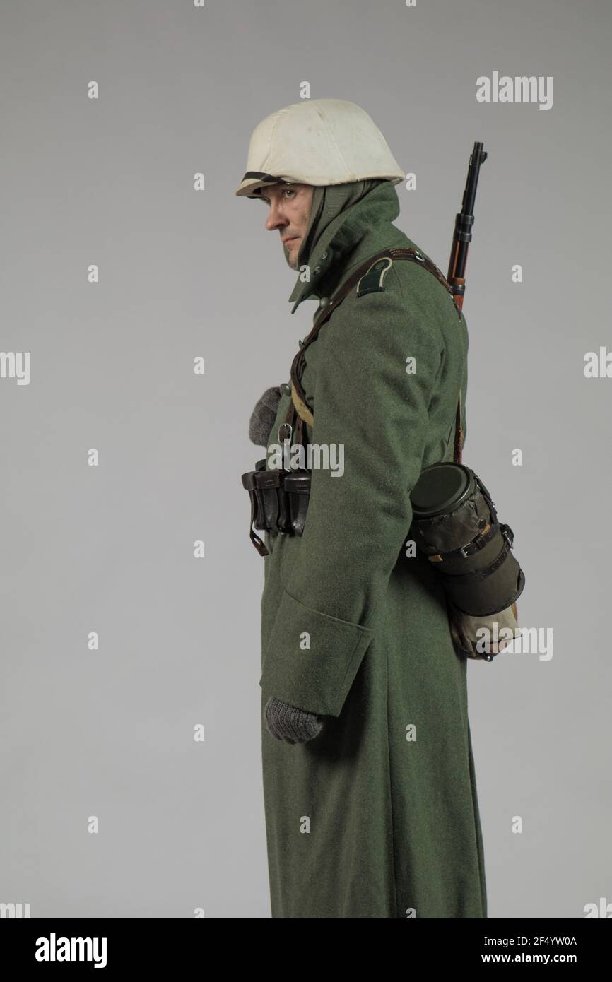 Männlicher Schauspieler in der Winteruniform eines deutschen Soldaten, der Periode 1942, dem Zweiten Weltkrieg, posiert auf grauem Hintergrund Stockfoto