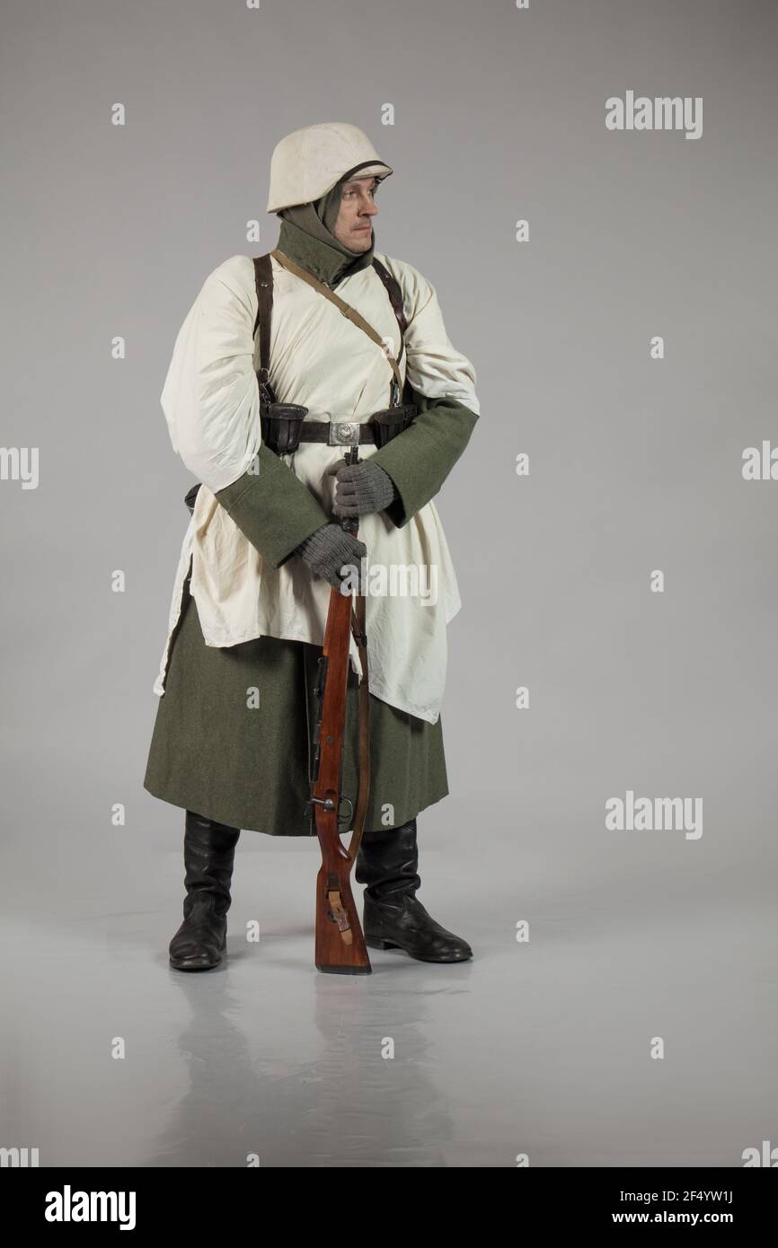 Männlicher Schauspieler in der Winteruniform eines deutschen Soldaten, der Periode 1942, dem Zweiten Weltkrieg, posiert auf grauem Hintergrund Stockfoto