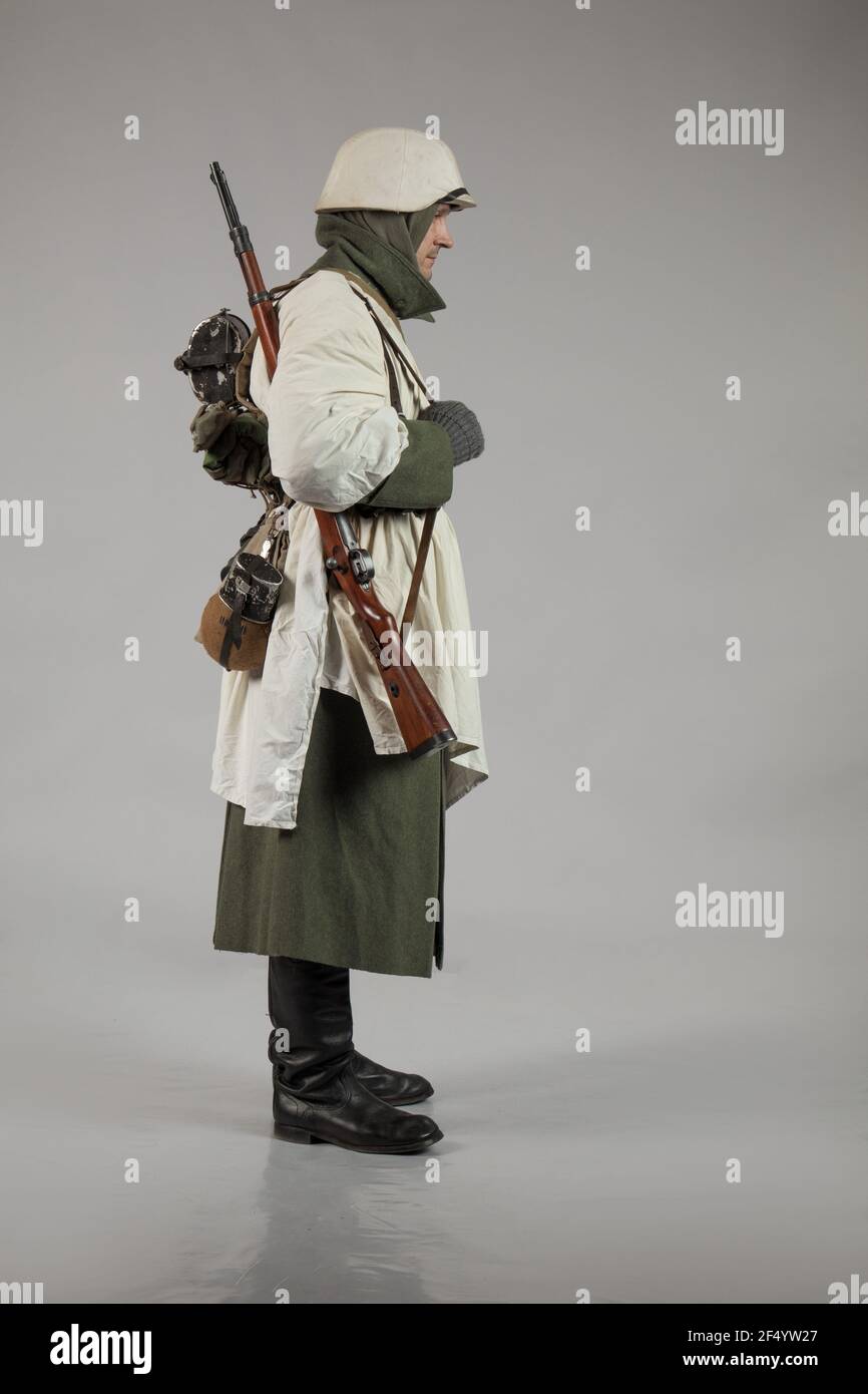 Männlicher Schauspieler in der Winteruniform eines deutschen Soldaten, der Periode 1942, dem Zweiten Weltkrieg, posiert auf grauem Hintergrund Stockfoto