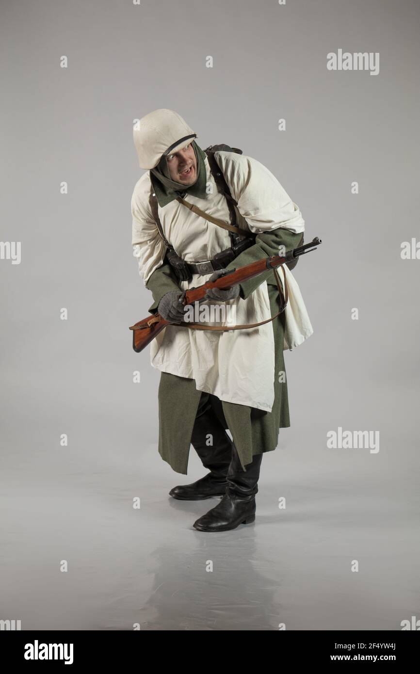 Männlicher Schauspieler in der Winteruniform eines deutschen Soldaten, der Periode 1942, dem Zweiten Weltkrieg, posiert auf grauem Hintergrund Stockfoto