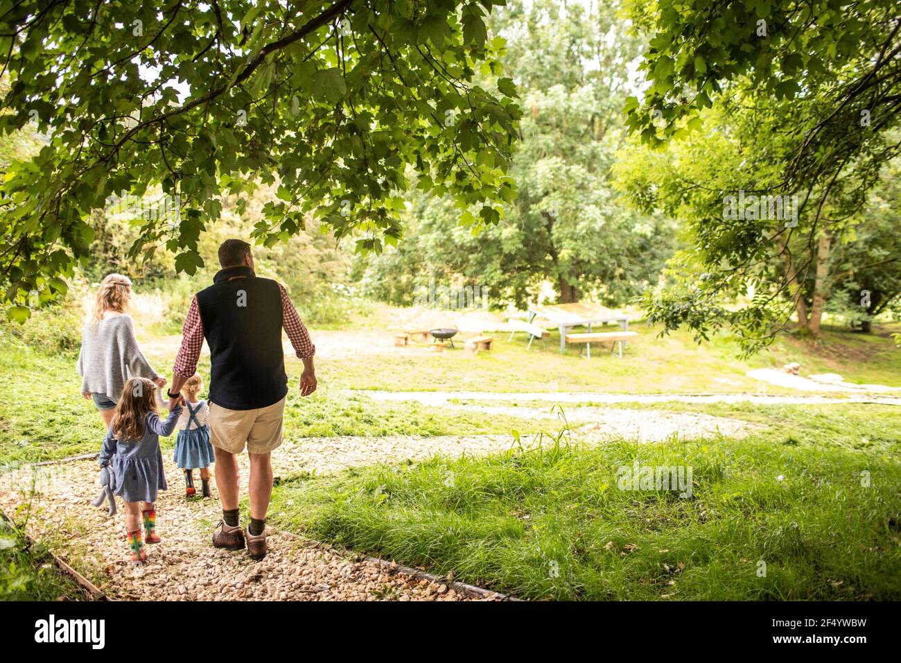 Familie hält Hände zu Fuß auf dem Weg in idyllischen Park Stockfoto