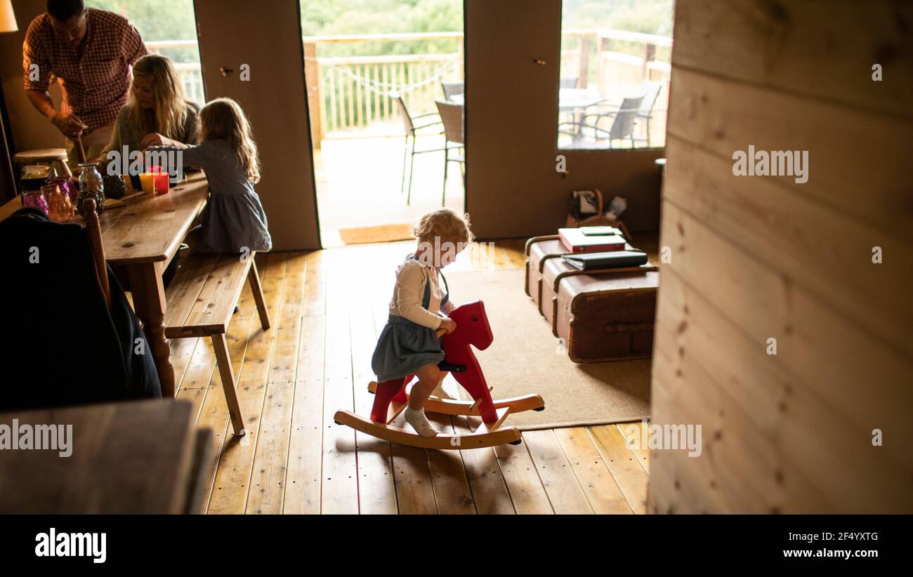 Nettes Mädchen spielen auf Schaukelpferd in Holz Kabine Stockfoto