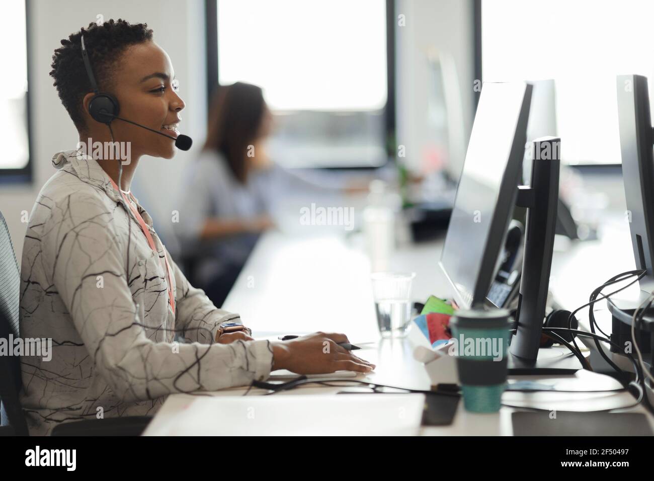 Geschäftsfrau mit Headset, die am Computer im Callcenter arbeitet Stockfoto