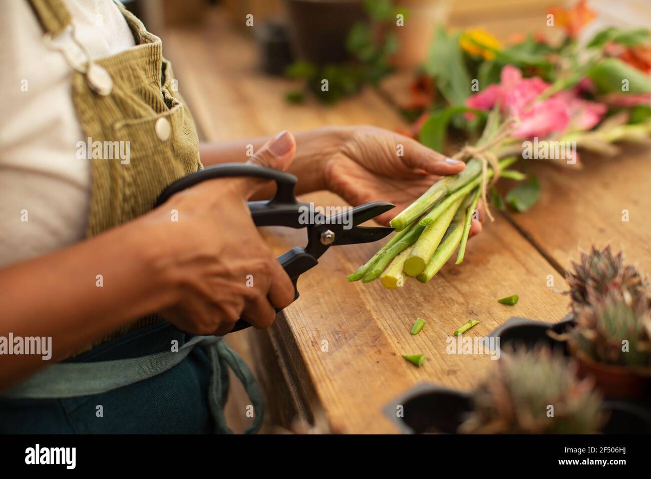 Weibliche Floristin Trimmen Blütenstängel mit Scheren Stockfoto